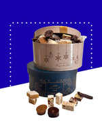 Boîte chapeau festive contenant nougats, calisson et chocolats dans coffret coloré.