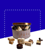 Boîte en métal blanche contenant nougats, calisson et chocolats variés.