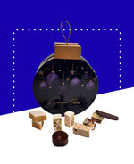 Boîte ronde de Noël contenant nougats, calissons et chocolats emballés variés.