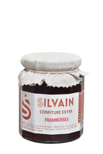 Un pot de gelée de framboise sans pépins, couleur rouge vif et texture lisse.