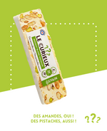 Nougat blanc avec pistaches et amandes, présenté dans un emballage élégant.