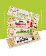 Quatre barres de nougat : amandes et pistaches, café, fruits rouges, agrumes confits.